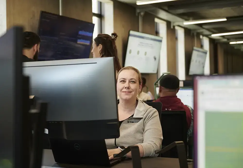 Kvinde foran computer smiler